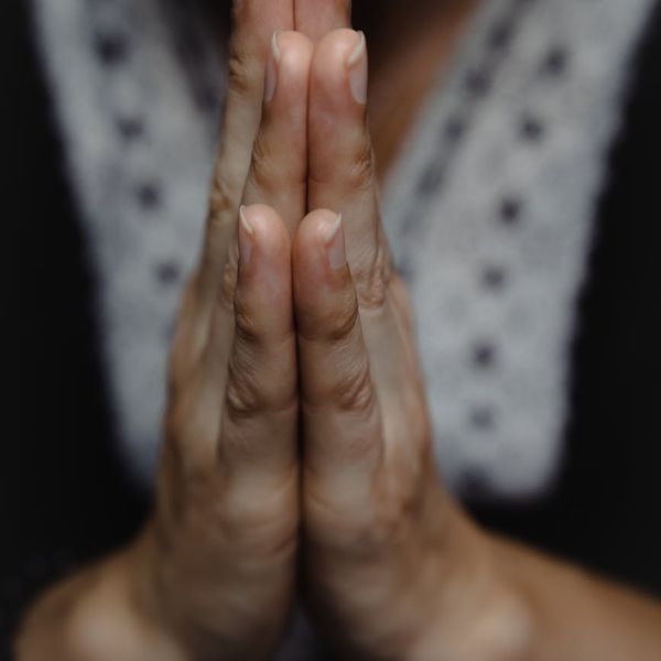 Close-up of a woman's hands in a meditative mudra gesture.